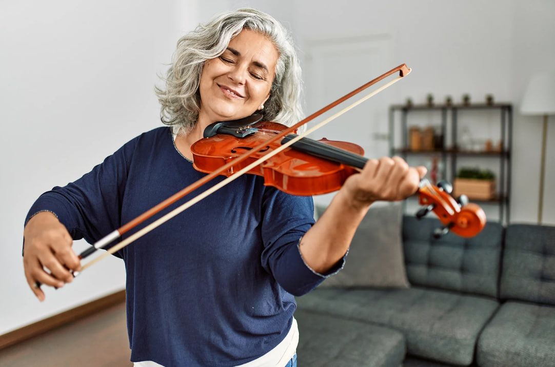 adult beginner playing violin at home during violin lessons for adults